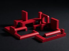 Crimson 3D architectural building blocks against a dark surface
